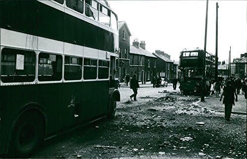 Vintage fotografija ljudi koji šeta ulicom i prolazi uništenim dvokatnim autobusom u Belfastu, Ireland.Target - jul 1970