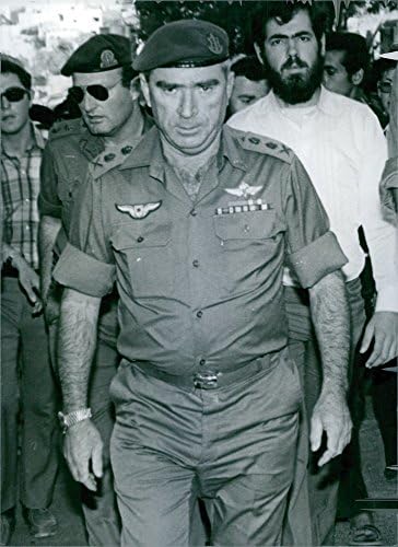 Vintage fotografija general-potpukovnika Raphaela Eitana, hoda sa muškarcima iza njega.